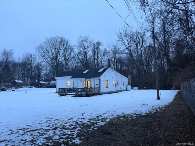 a view of white house with a yard covered in snow