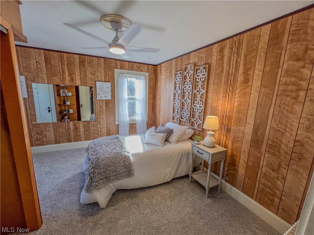 3110 Neosho Road Youngstown, OH 44511 - Photo 20 of 35 Carpeted bedroom featuring ceiling fan and wooden walls
