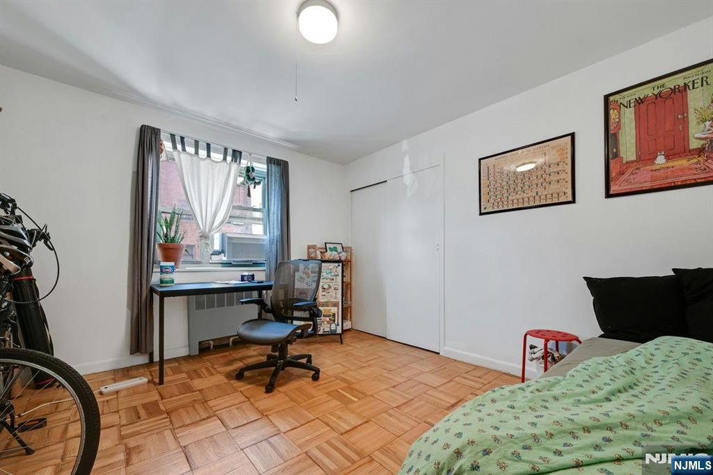 208 Anderson Street, Unit S5A Hackensack, NJ 07601 - Photo 13 of 17 a bedroom with a bed a desk and chair