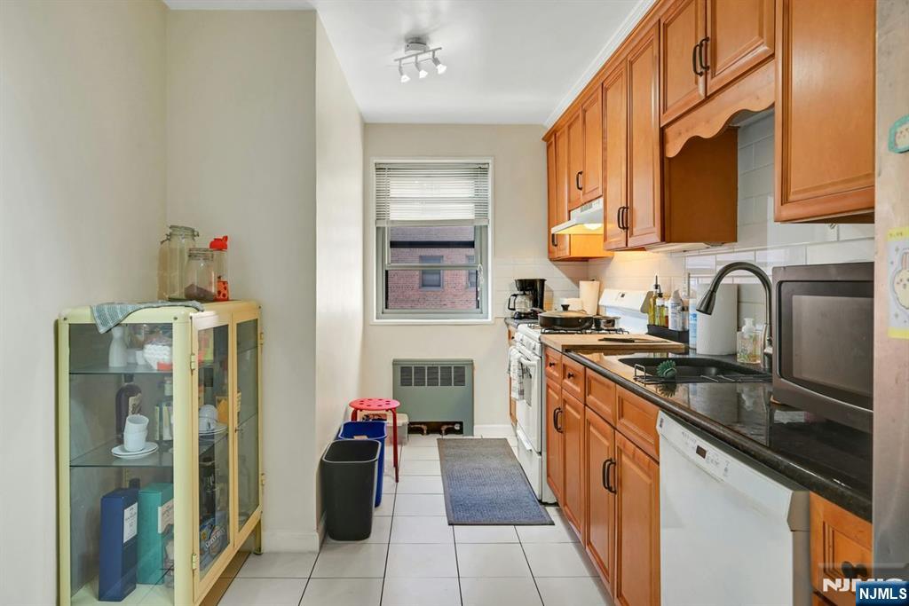 208 Anderson Street, Unit S5A Hackensack, NJ 07601 - Photo 7 of 17 a kitchen with stainless steel appliances granite countertop a sink and cabinets