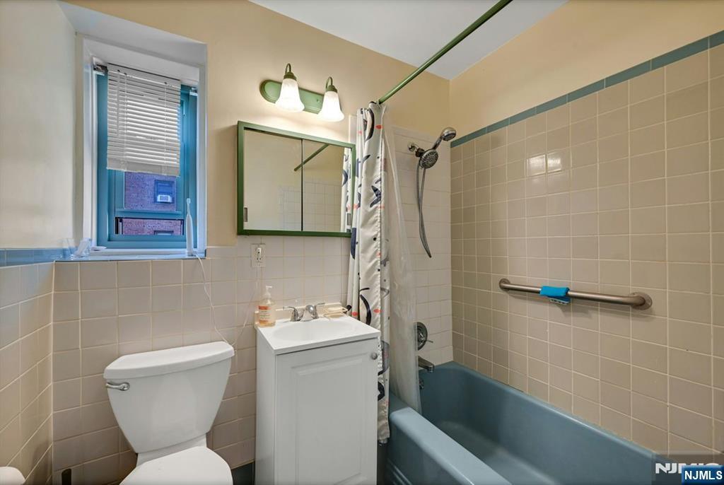 208 Anderson Street, Unit S5A Hackensack, NJ 07601 - Photo 10 of 17 a bathroom with a toilet sink and mirror