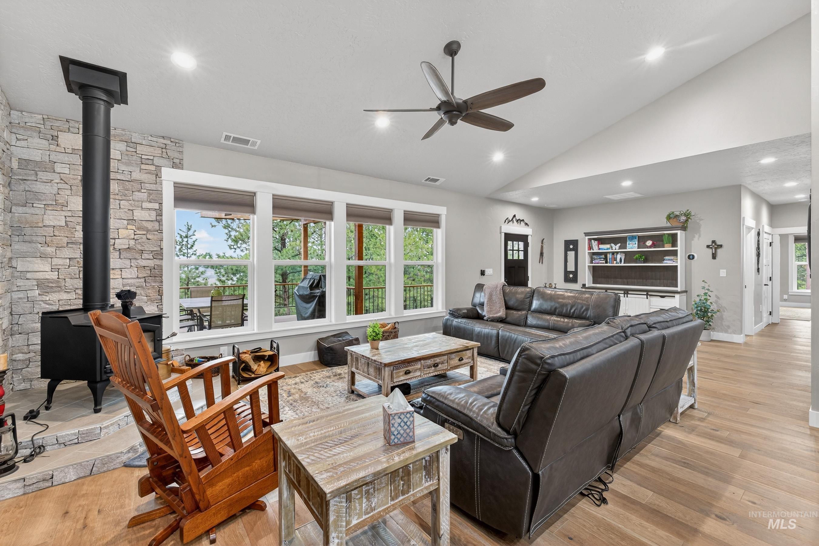 10191 Timberrim Drive Cascade, ID 83611 - Photo 19 of 44 Living area featuring ceiling fan, light wood-style floors, a wood stove, lofted ceiling, and recessed lighting