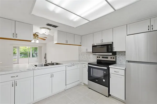 a kitchen with white cabinets and white appliances