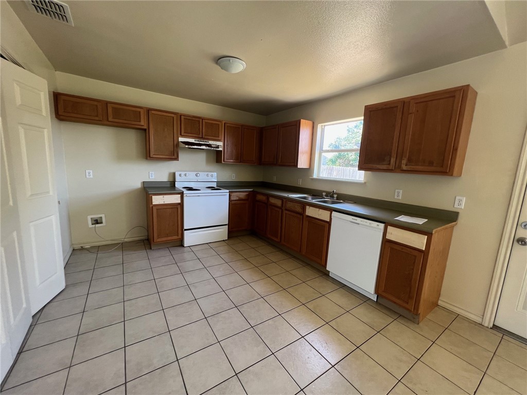 1409 Dewitt Street Corpus Christi, TX 78418 - Photo 3 of 9 a kitchen with stainless steel appliances granite countertop a stove sink and cabinets