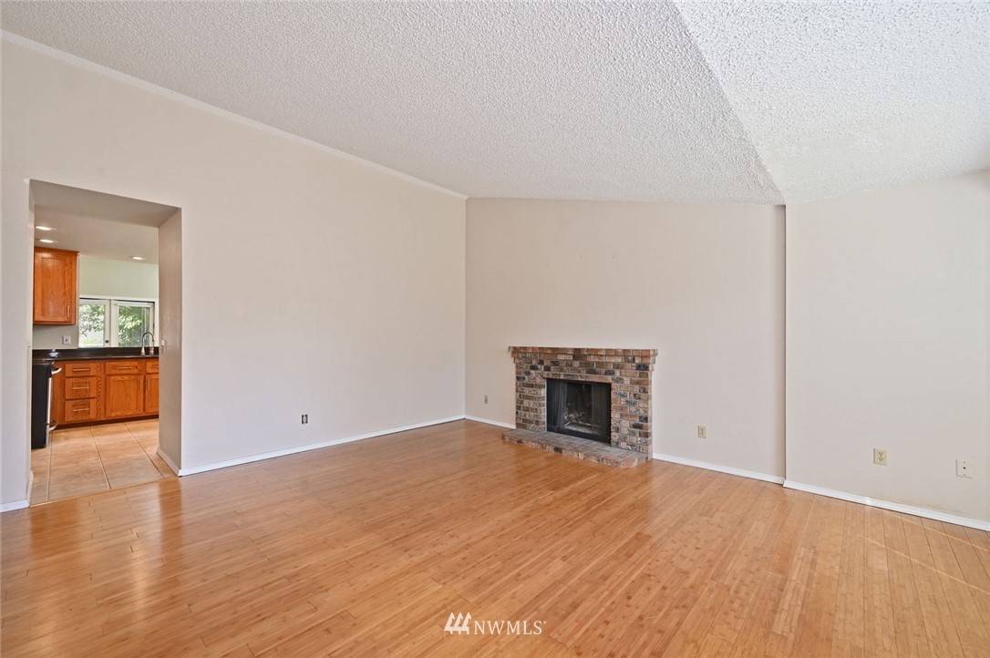 17733 114th Place Southeast Renton, WA 98055 - Photo 5 of 23 an empty room with wooden floor and a fireplace