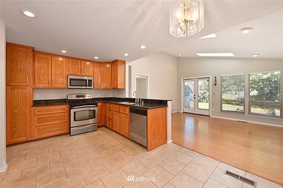 17733 114th Place Southeast Renton, WA 98055 - Photo 7 of 23 a kitchen with stainless steel appliances granite countertop a stove a sink and a microwave