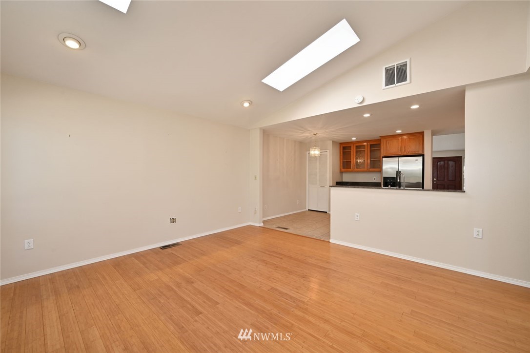 17733 114th Place Southeast Renton, WA 98055 - Photo 9 of 23 an empty room with wooden floor and a kitchen