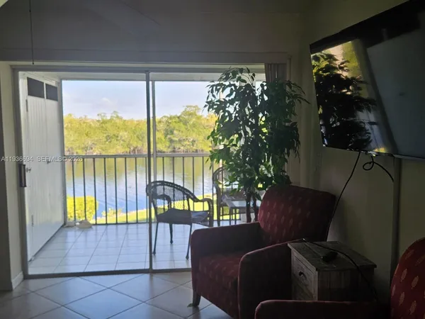 a living room with furniture and a floor to ceiling window