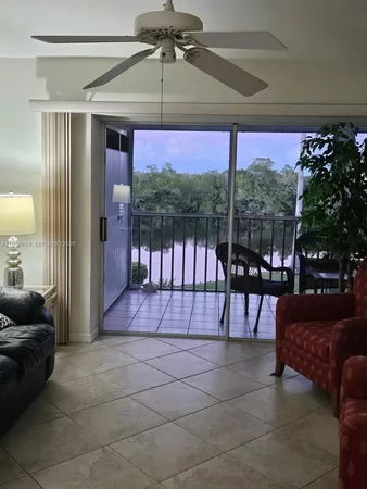 a living room with furniture and a floor to ceiling window