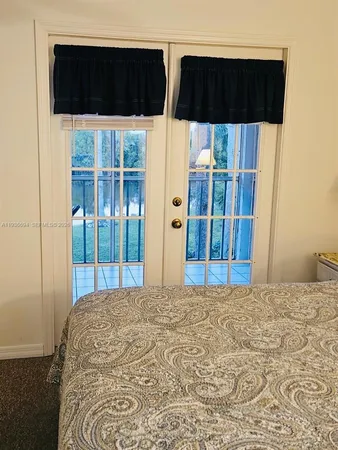 a view of a bedroom with wooden floor and windows