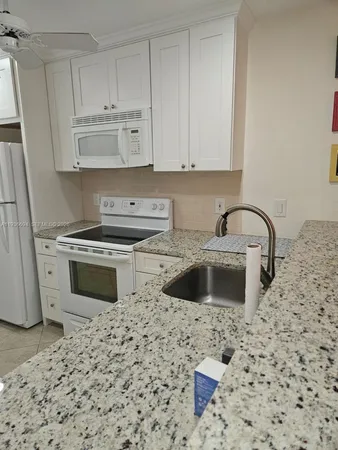 a kitchen with a stove a sink and a refrigerator
