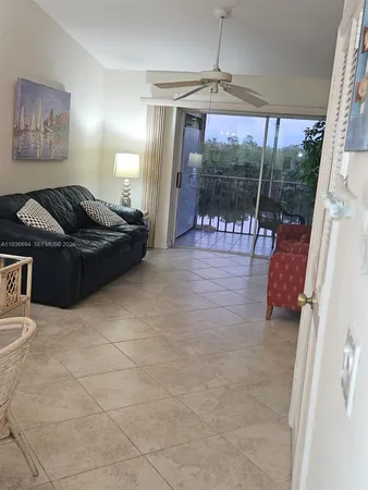 a living room with furniture and a floor to ceiling window
