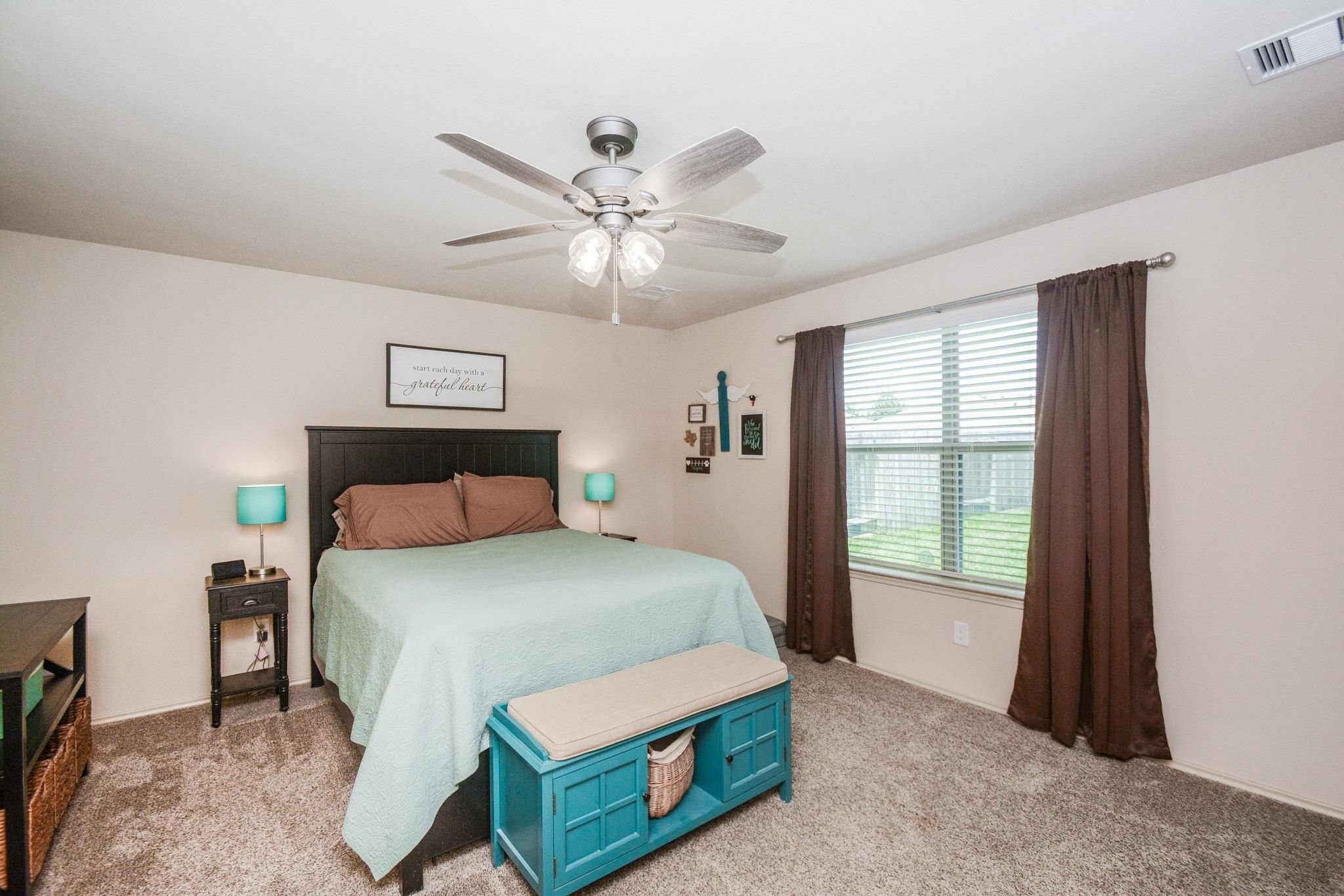 23318 Dukes Run Drive Spring, TX 77373 - Photo 25 of 41 This cozy bedroom features a neutral color palette with a large window providing natural light. It includes a ceiling fan and carpeted flooring.