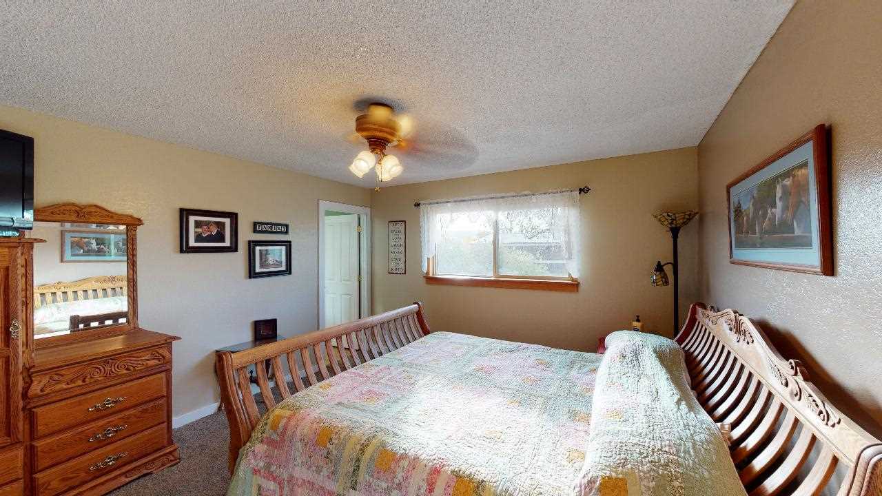 919 21 Road Fruita, CO 81521 - Photo 9 of 27 a bedroom with a bed and wooden floor