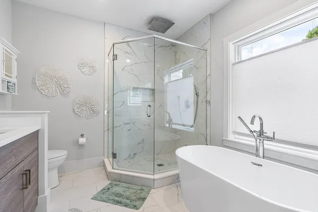 a bathroom with a shower a toilet and a sink