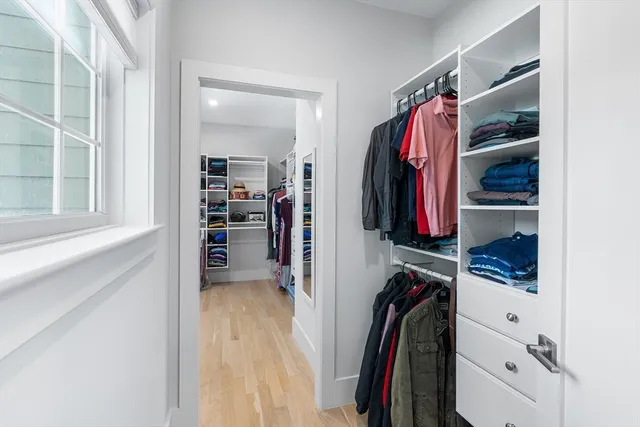 a view of walk in closet with clothes and shoes