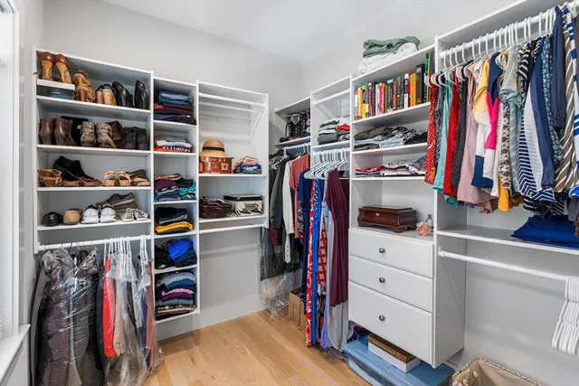 a view of walk in closet with clothes and shoes