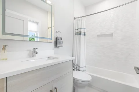 a bathroom with a double vanity sink toilet and shower