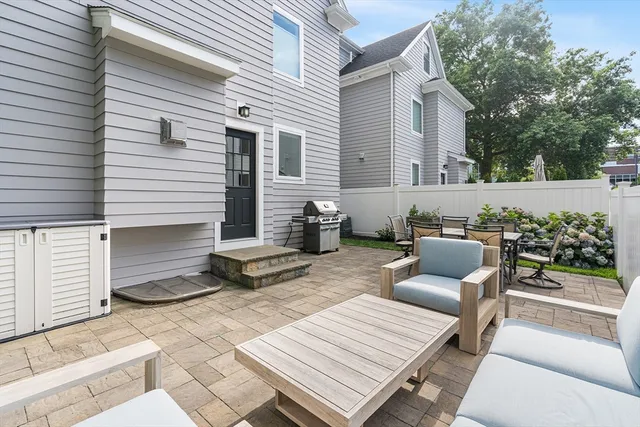 a view of a patio with couches and a dining table and chairs with wooden floor