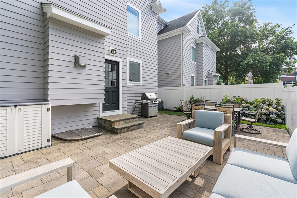 638 Webster Street, Unit 638 Needham, MA 02492 - Photo 37 of 42 a view of a patio with couches and a dining table and chairs with wooden floor