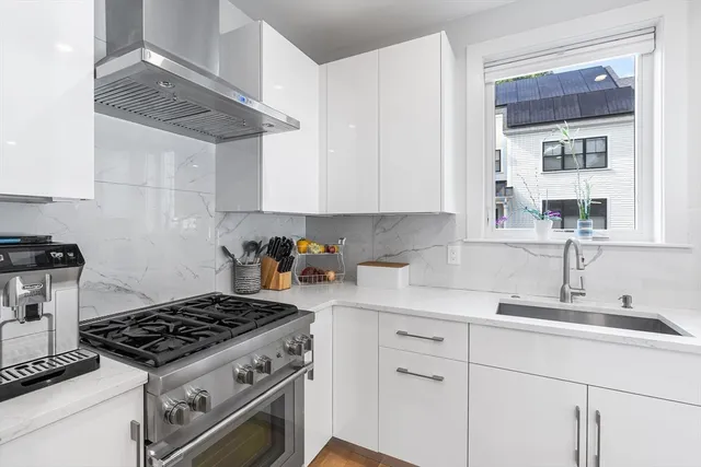 a kitchen with granite countertop a sink stainless steel appliances and cabinets