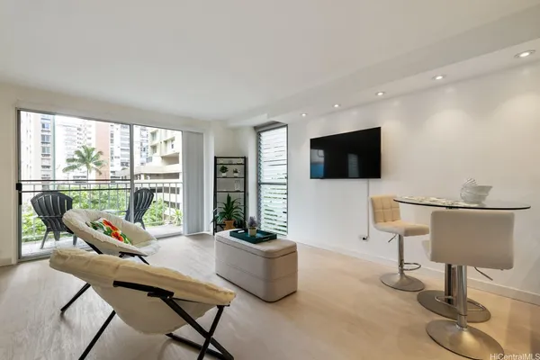a living room with furniture a flat screen tv and floor to ceiling window