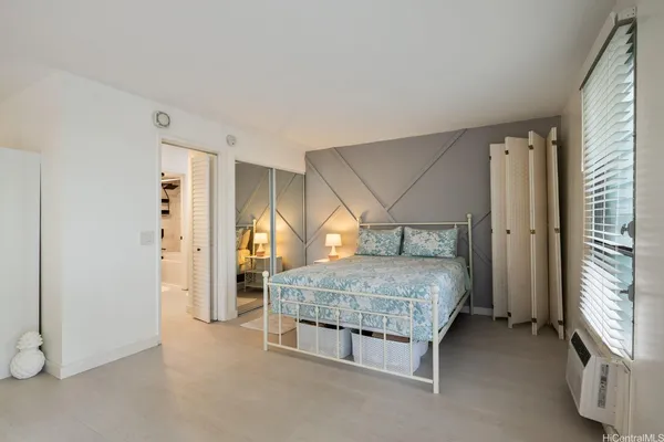 a spacious bedroom with a bed and a window