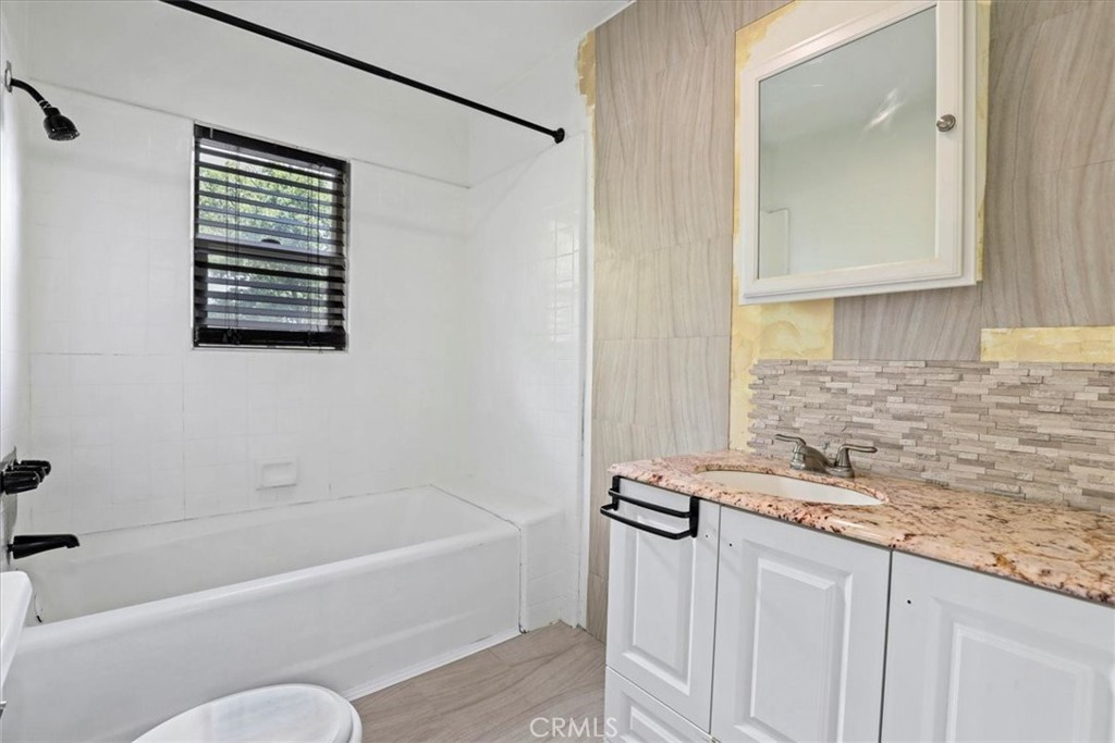 1352 Elm Avenue Long Beach, CA 90813 - Photo 43 of 71 a bathroom with a granite countertop tub a sink and a window