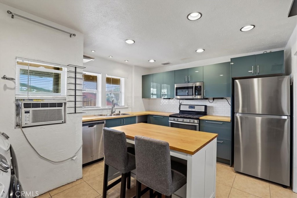 1352 Elm Avenue Long Beach, CA 90813 - Photo 54 of 71 a kitchen with stainless steel appliances granite countertop a refrigerator a stove a sink a dining table and chairs