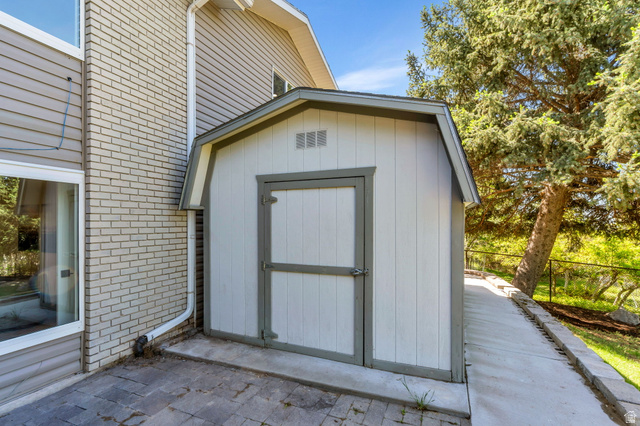 3813 North Foothill Drive Provo, UT 84604 - Photo 50 of 71 Gable-roof storage shed with white vertical siding and grey trim
