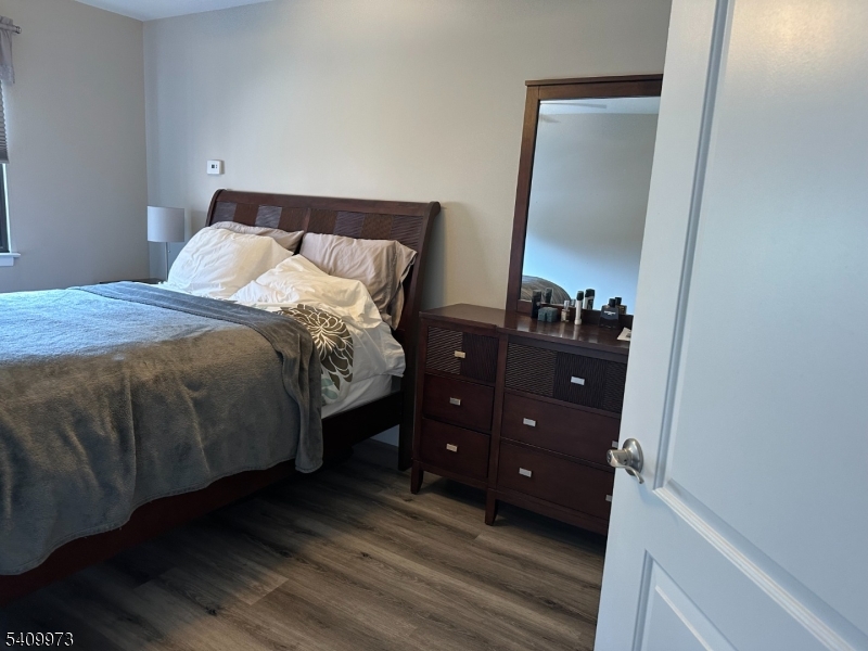 88 Boulevard, Unit 207 Passaic, NJ 07055 - Photo 8 of 13 a bedroom with a bed and a mirror on dresser