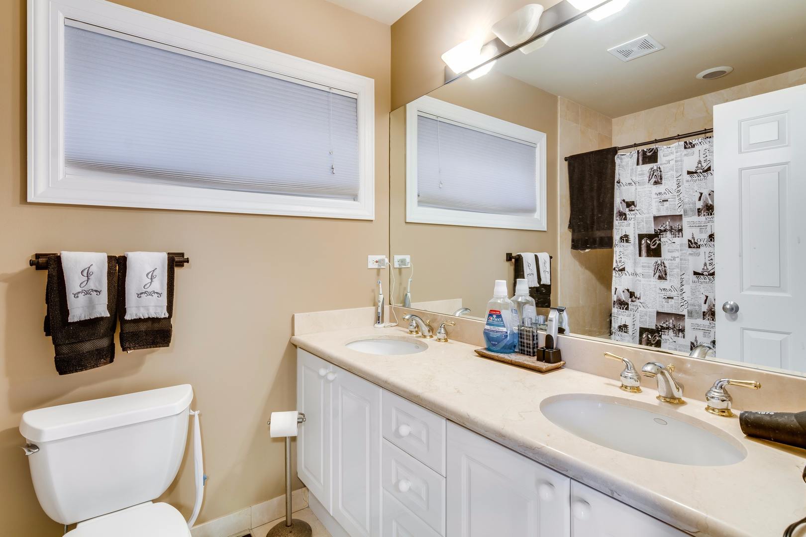 1645 West Addison Street, Unit 2 Chicago, IL 60613 - Photo 12 of 19 a bathroom with a granite countertop toilet sink and mirror