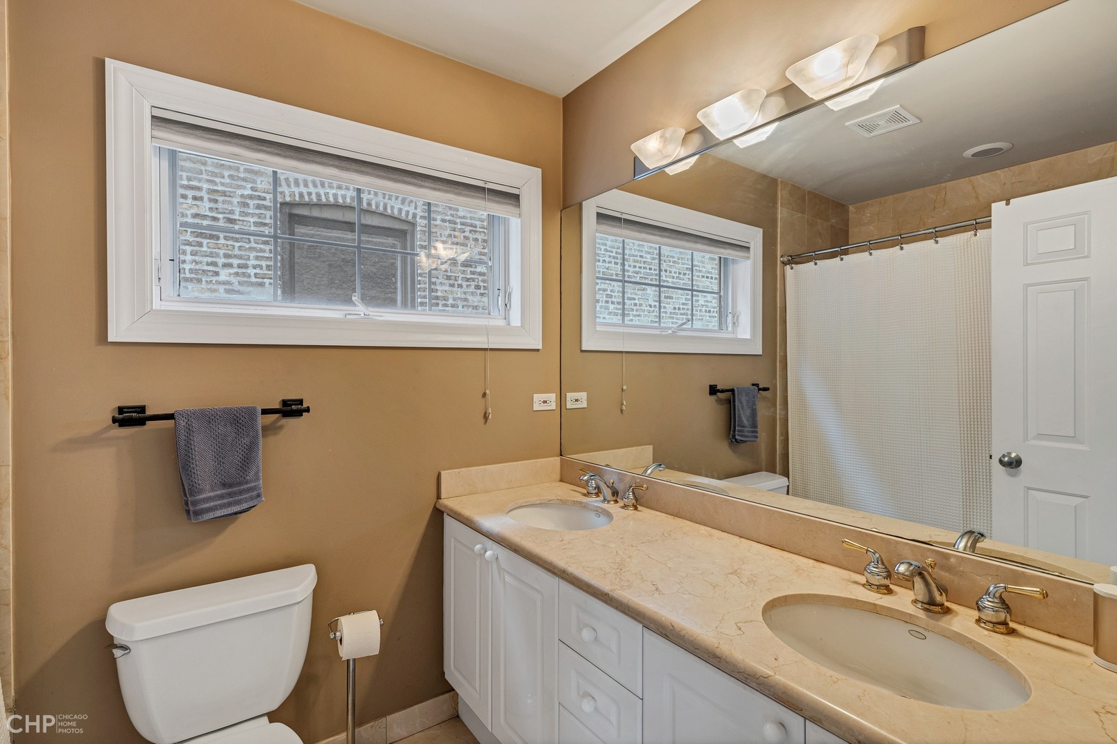 1645 West Addison Street, Unit 2 Chicago, IL 60613 - Photo 10 of 19 a bathroom with a granite countertop toilet sink and mirror