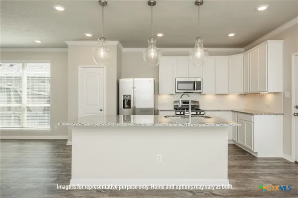 a kitchen with stainless steel appliances granite countertop a sink a stove and a refrigerator