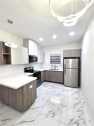 a kitchen with stainless steel appliances a refrigerator sink and microwave