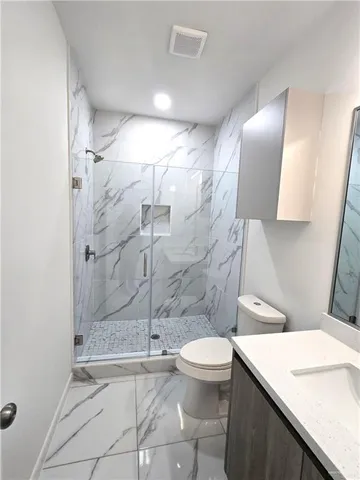 a bathroom with a sink a toilet and shower