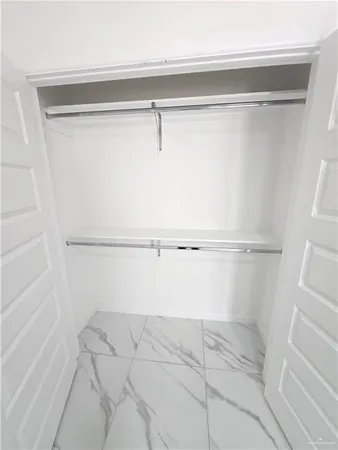 a view of walk in closet with empty racks