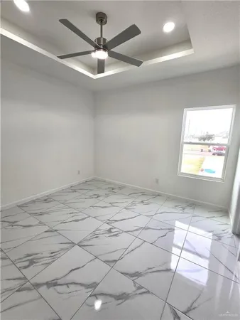a view of a room with a ceiling fan and window