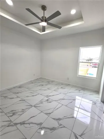 a view of a room with a ceiling fan and window
