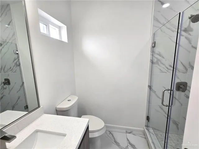 a white toilet sitting next to a shower
