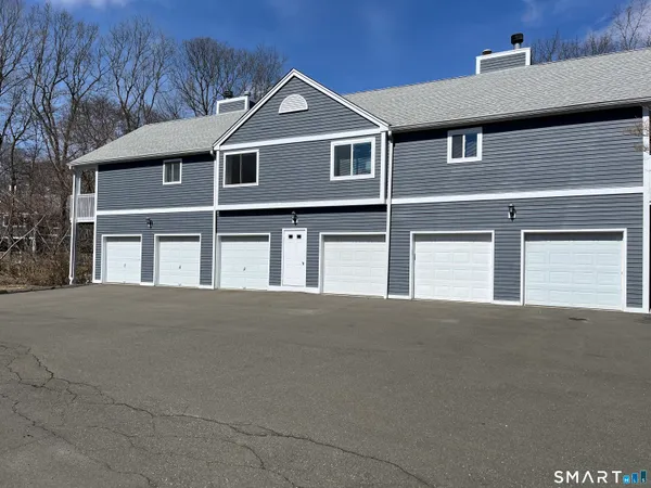 a front view of a house with garage and parking