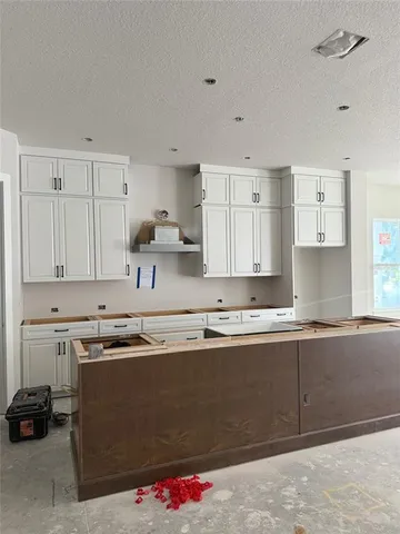 a kitchen with granite countertop white cabinets and white appliances