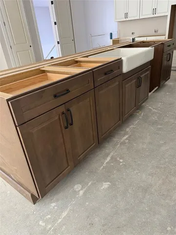 a kitchen with white cabinets and refrigerator