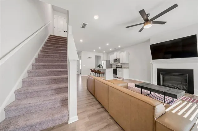 a living room with furniture a flat screen tv and kitchen view