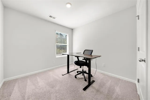 a view of a workspace with furniture and a window