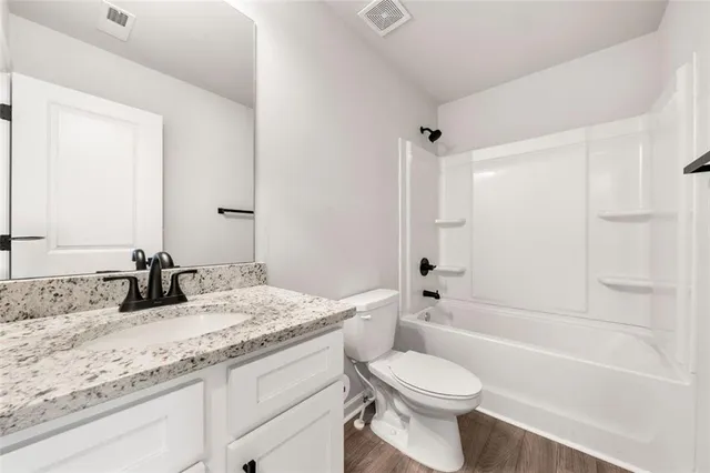 a bathroom with a granite countertop toilet sink and bathtub