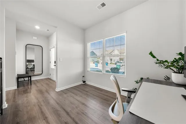 a view of a workspace with furniture and a window