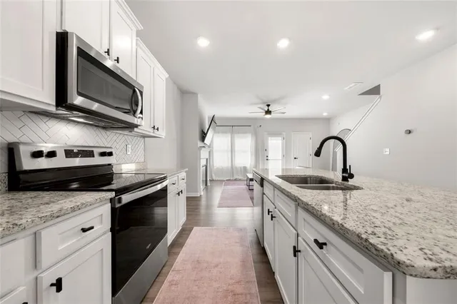 a kitchen with stainless steel appliances granite countertop a sink and microwave