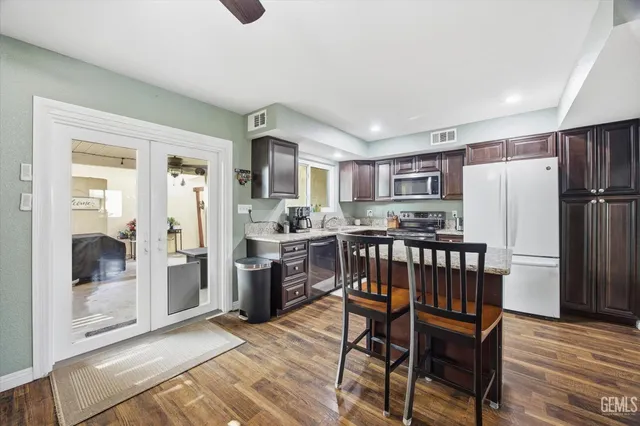 a kitchen with stainless steel appliances wooden floor and refrigerator