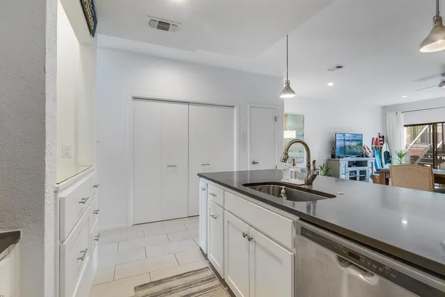a kitchen with granite countertop white cabinets and a sink
